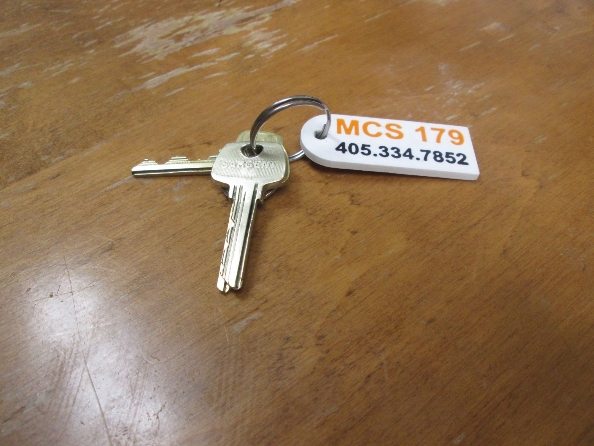 A single key and its printed keychain tag resting on a table