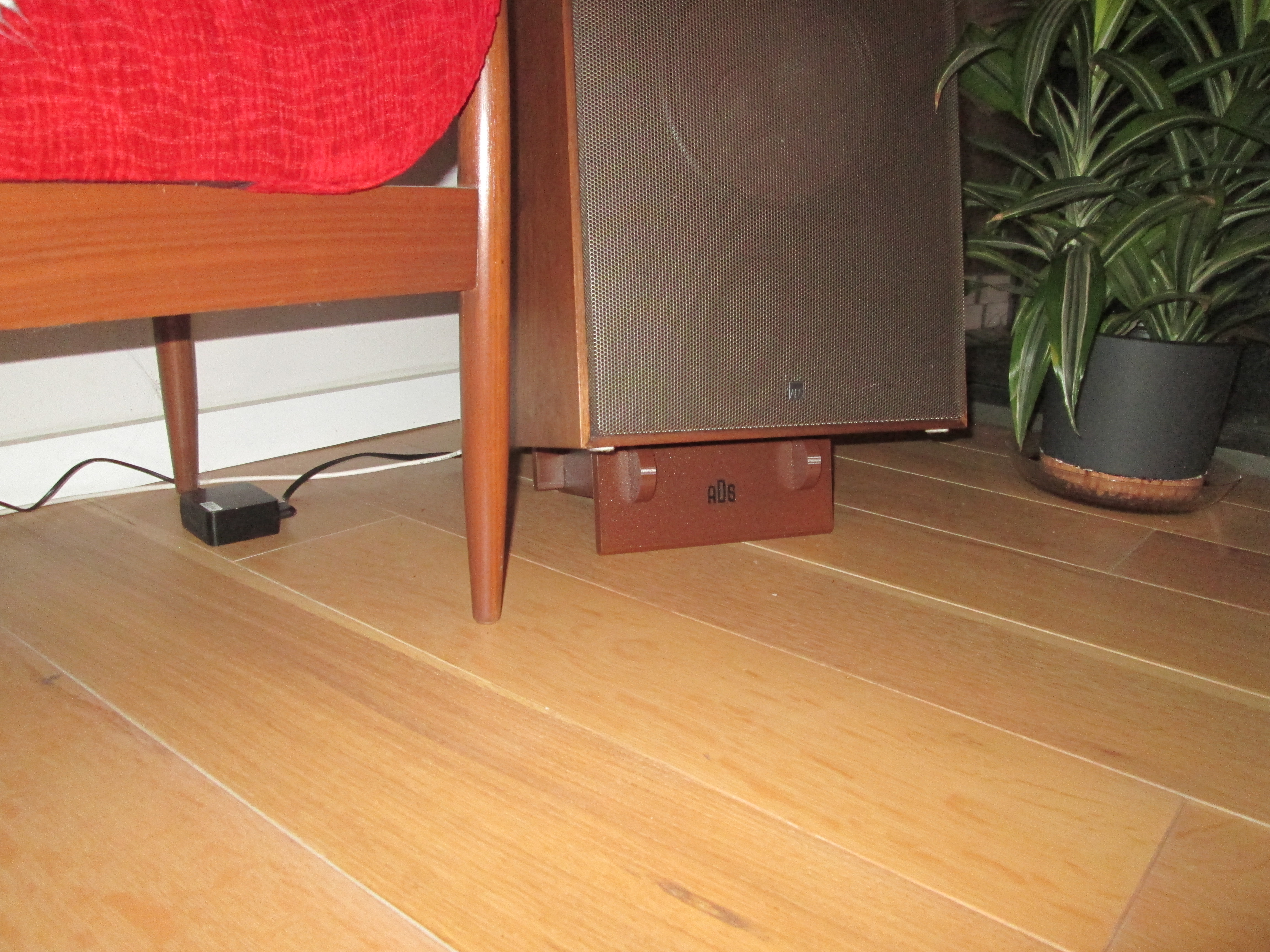 Close-up of the printed riser under the speaker cabinet, finished to match the wood grain