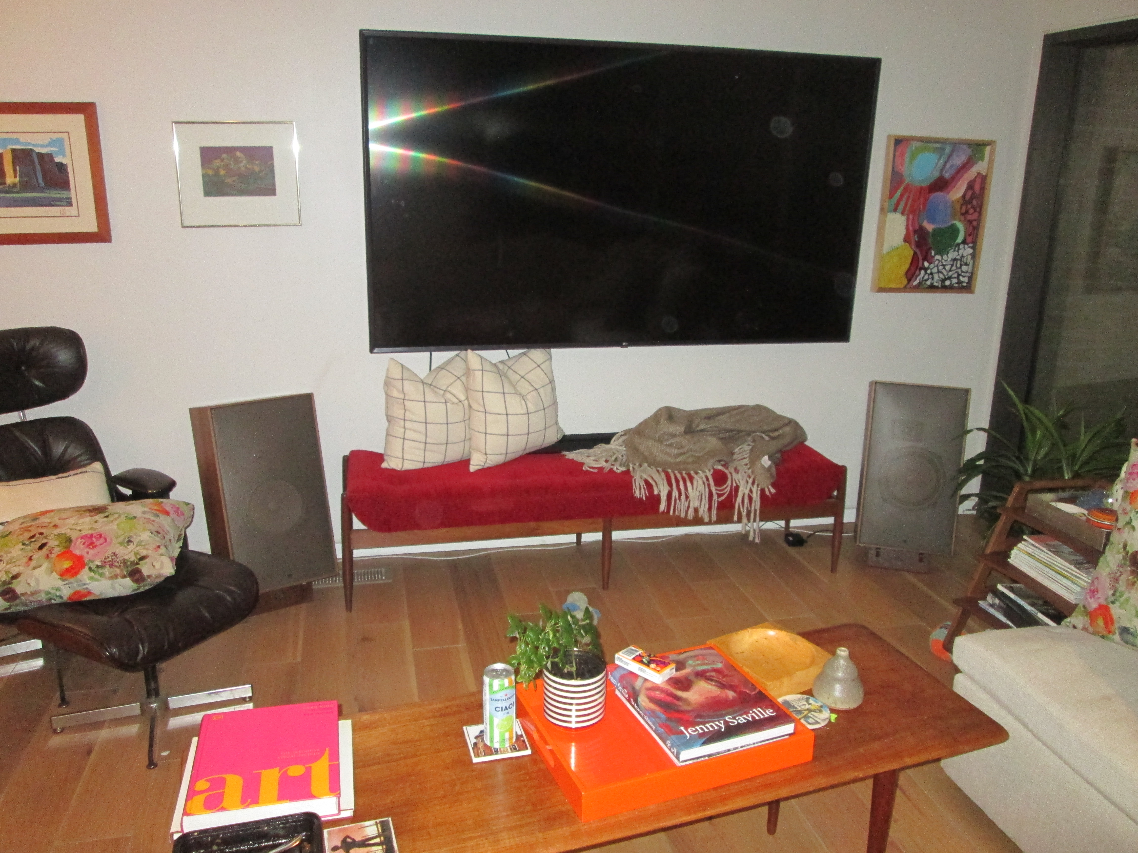 A pair of vintage bookshelf speakers on their wood-look printed stands, flanking the TV console in the living room